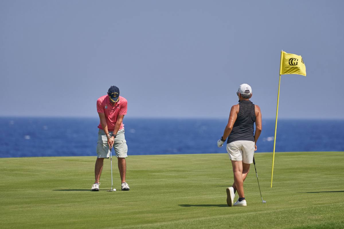 Golfers on a Somabay green by the sea